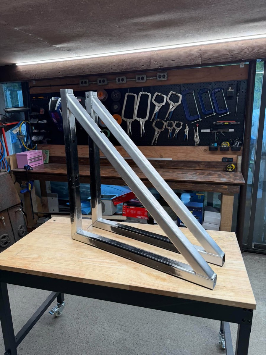 Two finished aluminum triangle braces welded from customer-supplied material