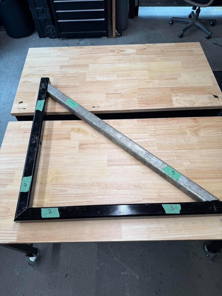 Customer's pre-cut, numbered steel tube pieces laid out on the bench