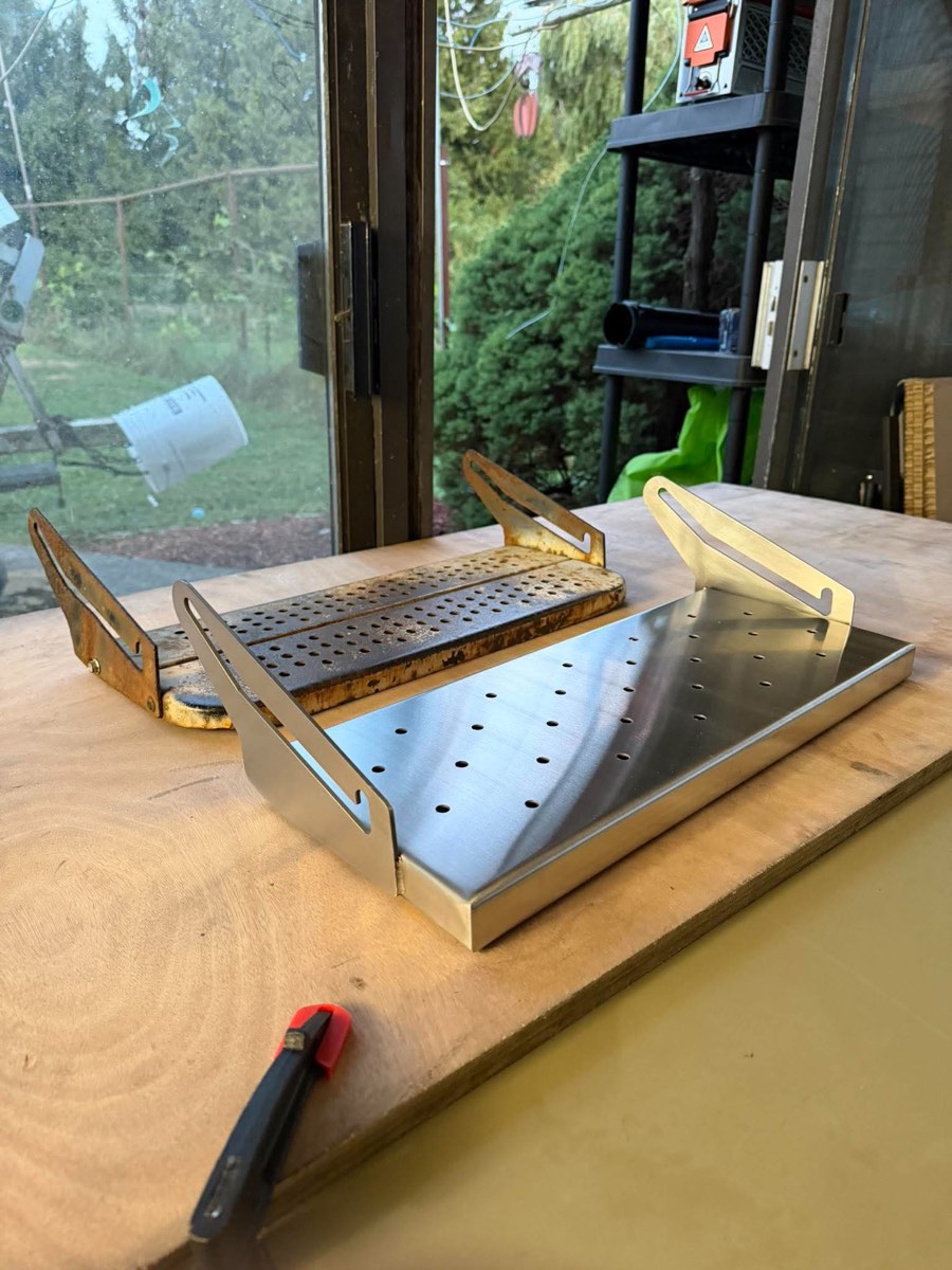 New stainless RV slide-out step beside the rusted original